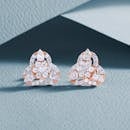 Luxurious diamond earrings with an intricate design on a textured background.