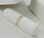 Close-up of an elegant gold ring with diamonds, showcased on a white background.