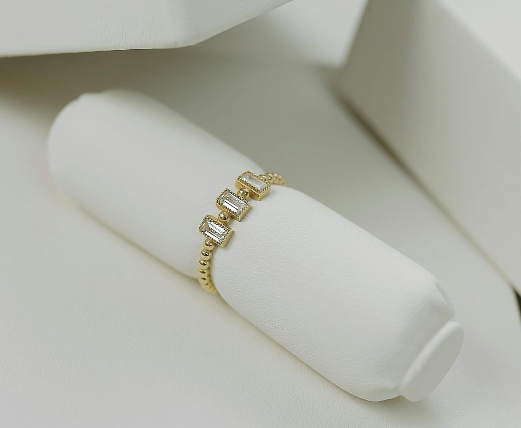 Close-up of an elegant gold ring with diamonds, showcased on a white background.