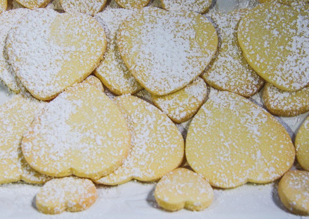 A pile of heart-shaped sugar cookies dusted with powdered sugar. Perfect for Valentine's Day.